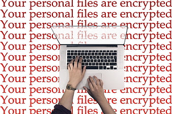 Laptop with ransomware warning text background