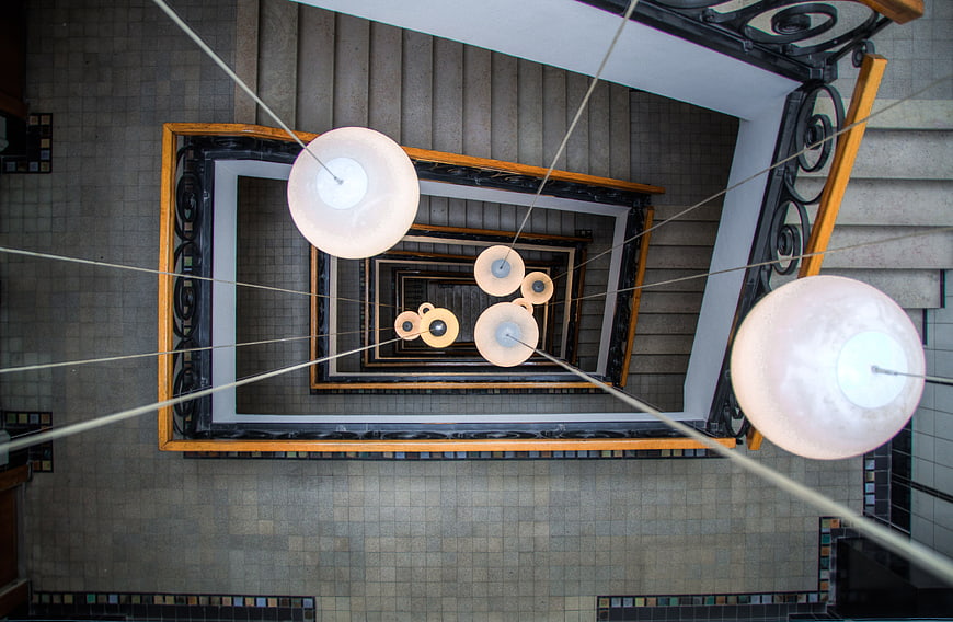 Top-down view of modern spiral staircase with pendant lights
