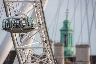 Passengers in glass cabin of white Ferris wheel