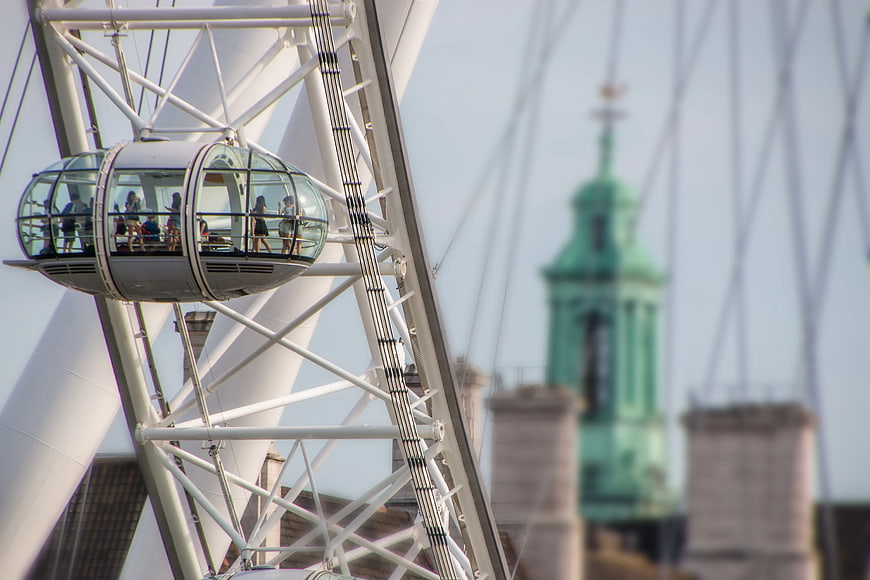 Passengers in glass cabin of white Ferris wheel