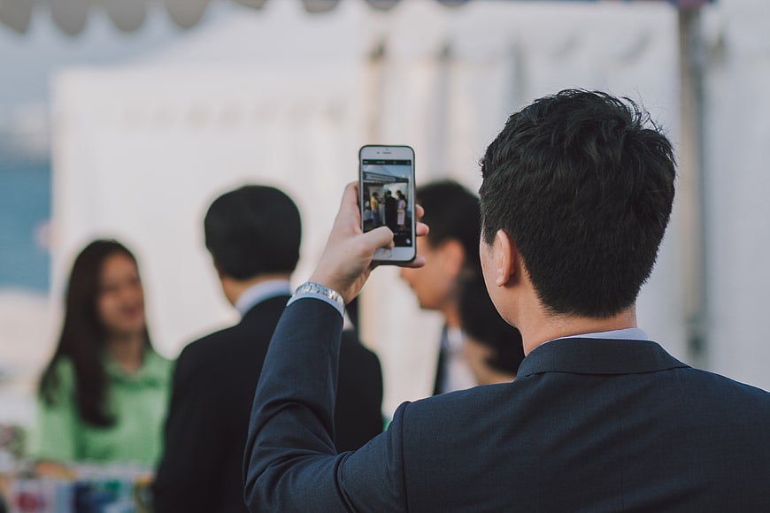 Man Taking Photo with Smartphone at Outdoor Business Event