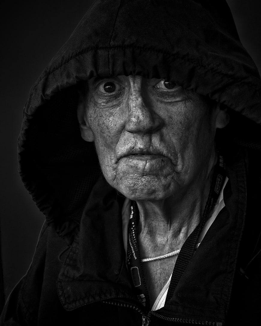 Intense Black and White Portrait of Elderly Man in Hood