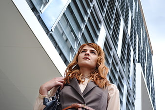 Woman in Business Attitude Looking Up at Modern Office Building