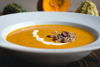 Creamy Pumpkin Soup with Hazelnuts and Cream Garnish