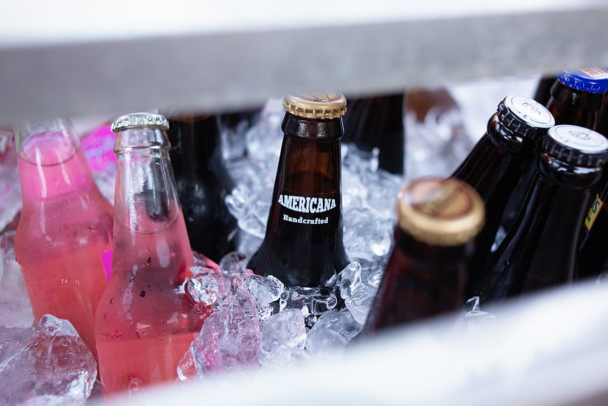 Assorted Craft Beer and Soda Bottles in Ice Cooler