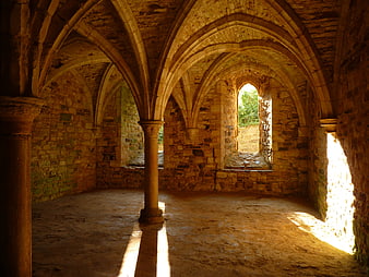 Historic Stone Vaulted Interior With Arched Windows And Pillars