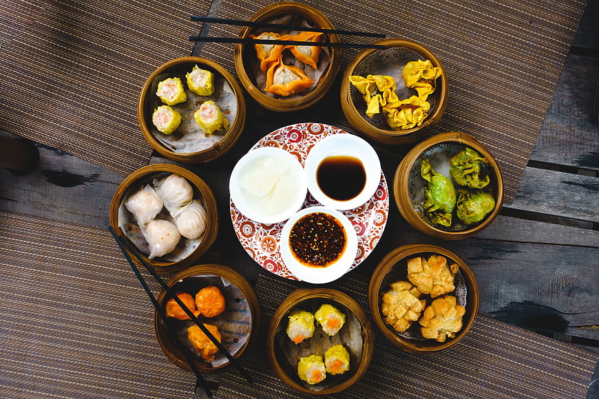 Top view of assorted Chinese dim sum in bamboo steamers