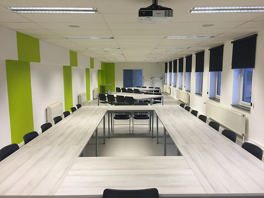 Modern Classroom with White Tables and Green Wall Accents