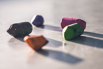 Colorful Chalk Pieces on White Surface with Shadows