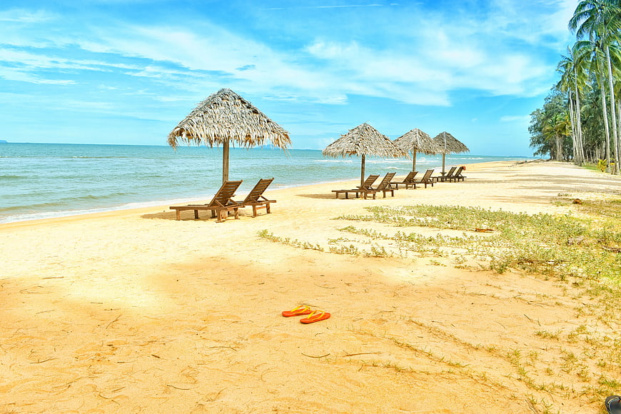 Tropical Beach with Thatched Umbrellas and Orange Flip Flops