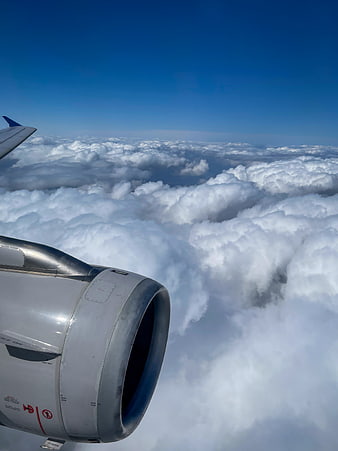 Airplane Engine and Wing View Above Clouds