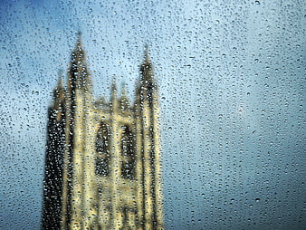 Raindrops on window with blurred gothic cathedral background