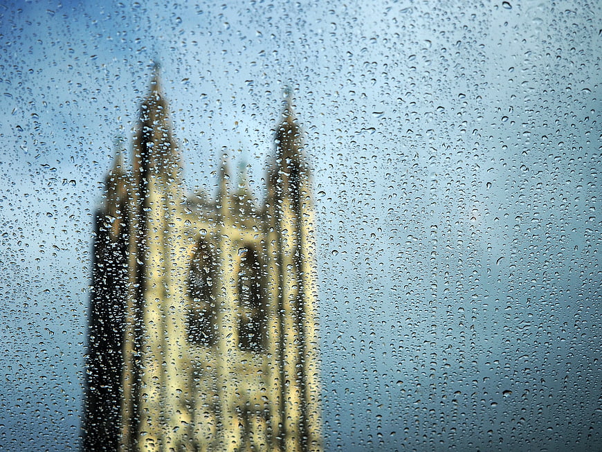 Raindrops on window with blurred gothic cathedral background