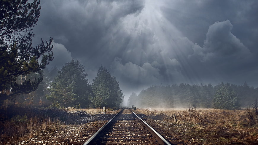 Dramatic Railway Tracks Leading Into Stormy Forest Landscape