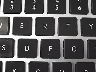 Close-up of black laptop keyboard keys on silver background