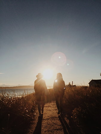 Silhouette of Couple Walking on Coastal Path at Sunset