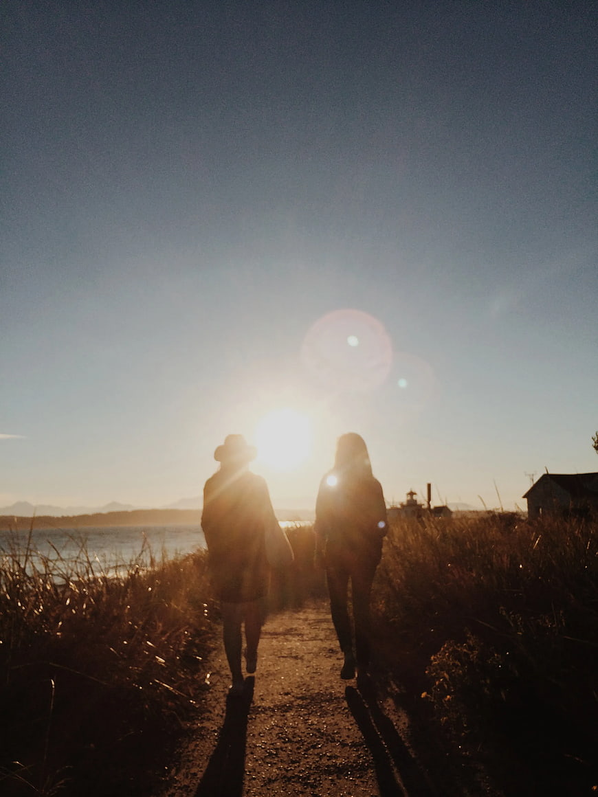 Silhouette of Couple Walking on Coastal Path at Sunset