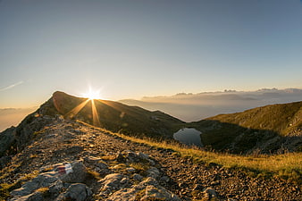 Sunrise over mountain ridge with alpine lake and fog