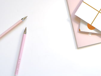 Pink Pens and Notebooks on White Desk with Copyspace