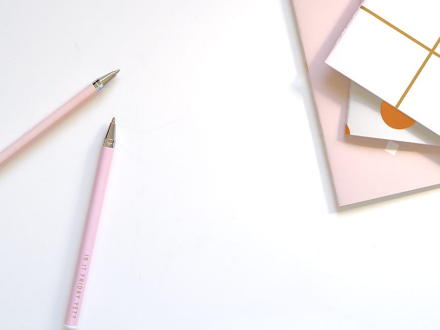 Pink Pens and Notebooks on White Desk with Copyspace