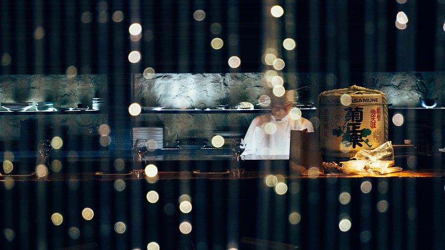 Chef in Japanese Restaurant Kitchen Through Rainy Window
