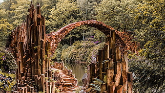 Historic Stone Arch Bridge Over Pond In Lush Forest