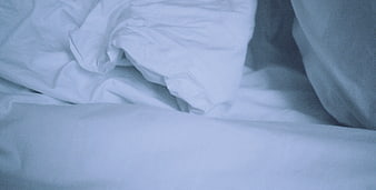 Close-up of rumpled white bed sheets and pillow