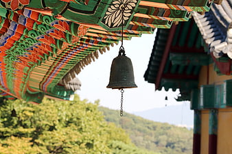 Traditional Korean Temple Bell Hanging Under Colorful Eaves