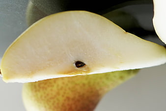 Close-up of a sliced pear with visible seed and textured skin