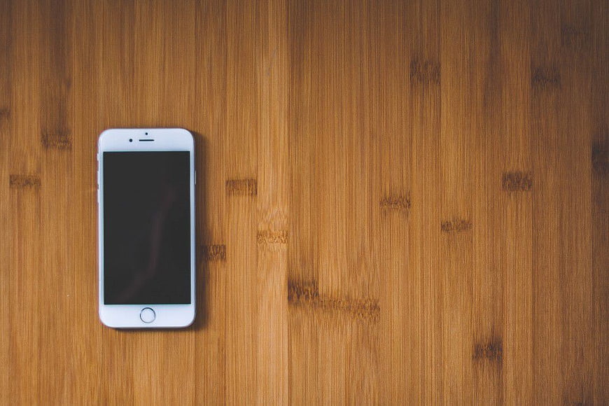 White Smartphone on Wooden Surface Top View