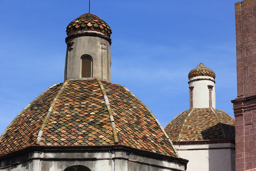 Colorful tiled domes of a historic church in Bosa, Sardinia