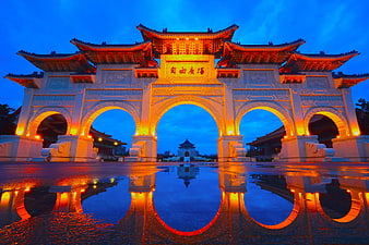 Traditional Chinese Archway Illuminated at Dusk with Water Reflection