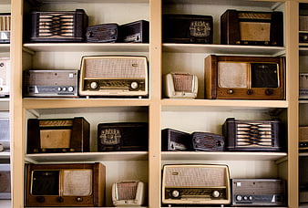 Collection of vintage radios on wooden shelves