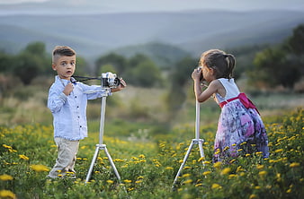 Cute children playing photographers in a flower field