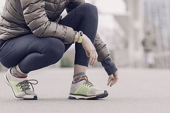 Female runner tying shoelaces on city street