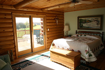 Cozy Log Cabin Bedroom Interior With Sliding Glass Doors And Mountain View