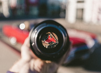 Camera lens reflection of red vintage car