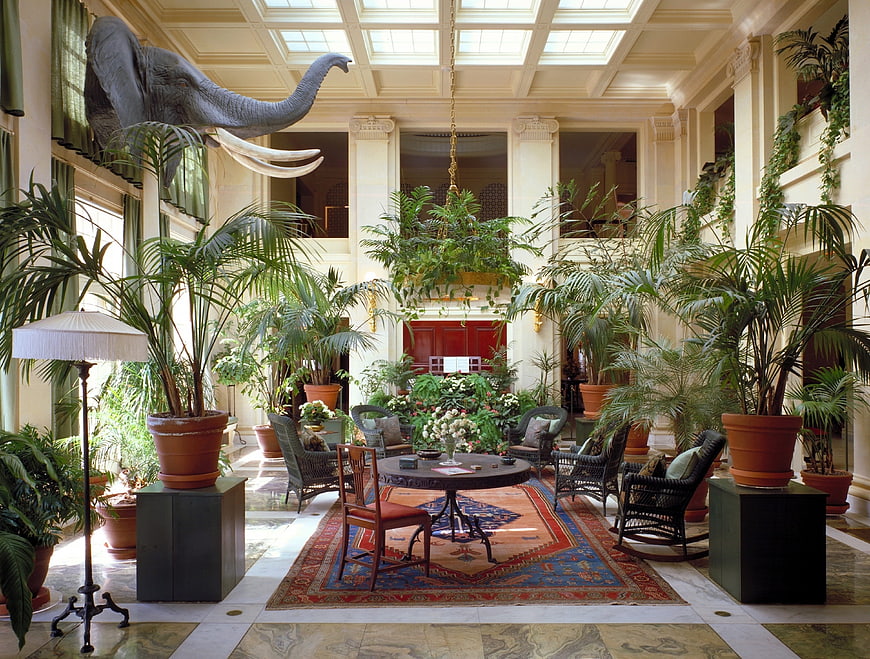 Luxurious Indoor Conservatory With Elephant Sculpture And Tropical Plants