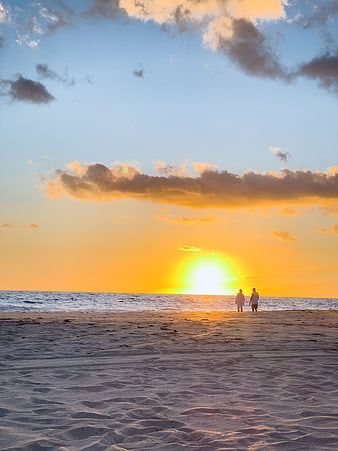 Couple Walking on Sandy Beach at Golden Sunset