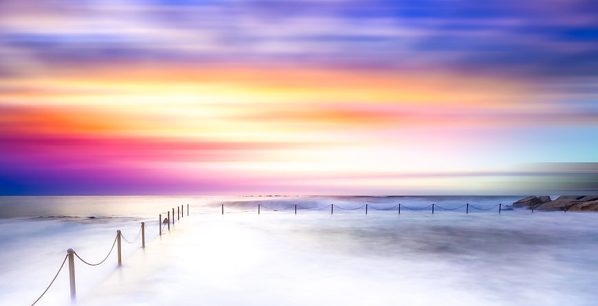 Vibrant Long Exposure Sunset Over Misty Ocean Beach
