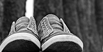 Black and white sneakers on wooden surface