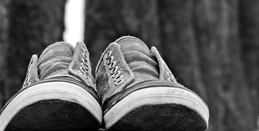 Black and white sneakers on wooden surface
