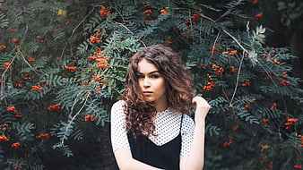 Portrait of young woman with curly hair in nature