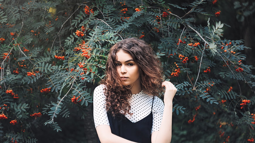 Portrait of young woman with curly hair in nature