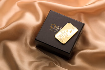 Gold bar on black box with silk background
