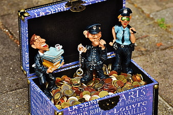 Satirical figurines of police and tax evasion in a treasure chest