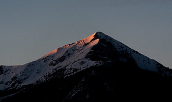Snow-Capped Mountain Peak at Sunset with Golden Light