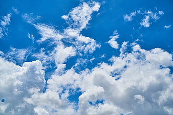 Fluffy white clouds against a vibrant blue sky background