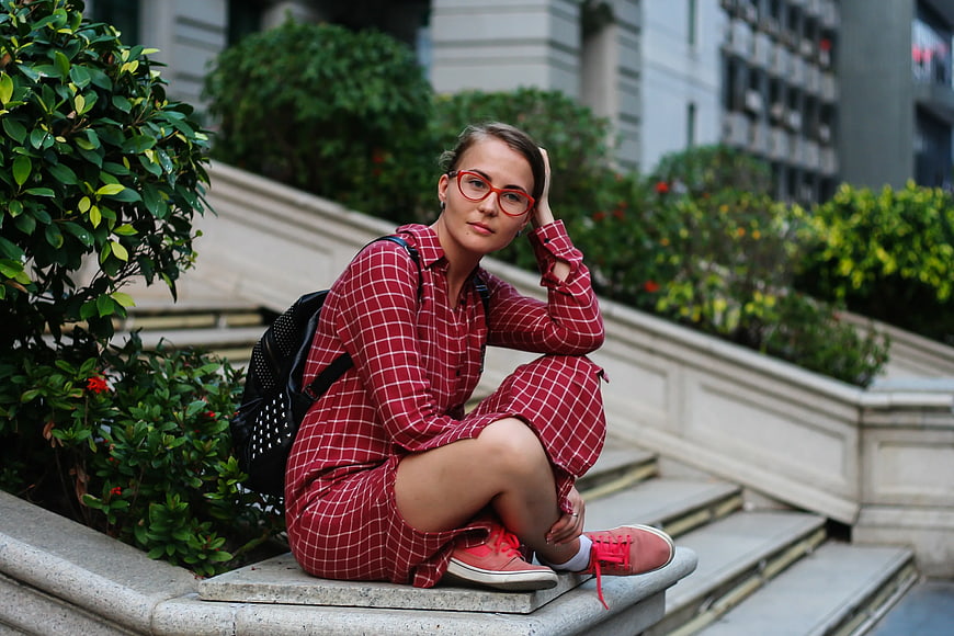 Woman in Red Plaid Dress Sitting on Urban Steps
