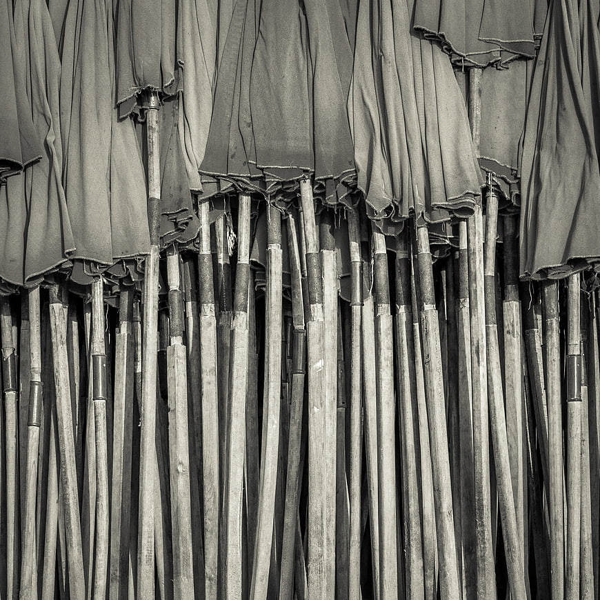 Black and white texture of closed beach umbrellas